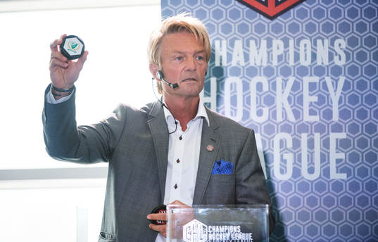 s ordförande Anders Ternbom håller upp en puck för