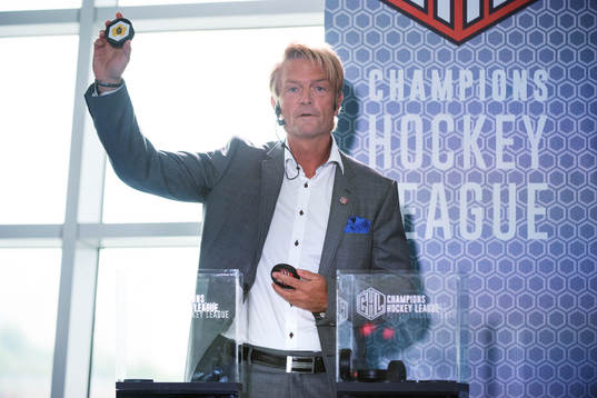 s ordförande Anders Ternbom håller upp en puck för