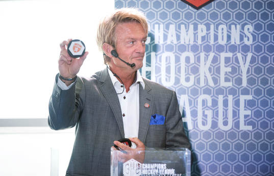 s ordförande Anders Ternbom håller upp en puck för