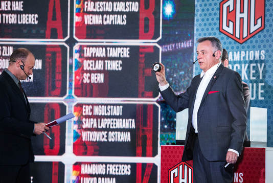 s informationsansvarige Szymon Szemberg håller upp en puck