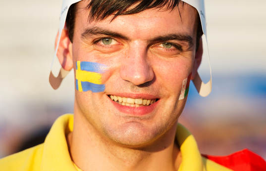 Ett fan med svenska och vitryska flaggorna målade på sina