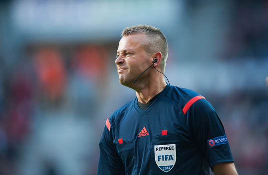 Domaren Svein Oddvar Moen visar gula kortet och delar ut