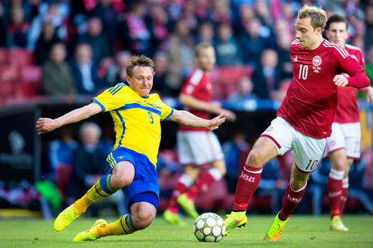 Sveriges Kim Källström jagar boll framför Danmarks