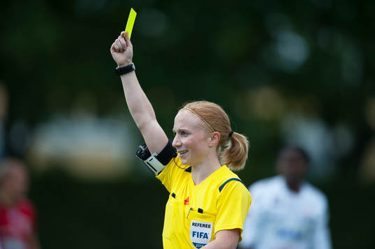Domaren Linn Andersson visar gult kort i matchen i