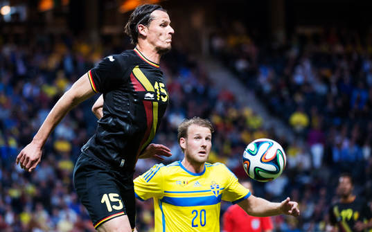 Belgiens Daniel Van Buyten tar ner bollen framför Sveriges