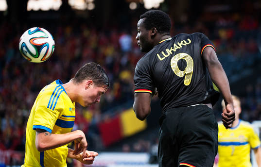 Sveriges Mikael Lustig förlorar en nickduell med Belgiens