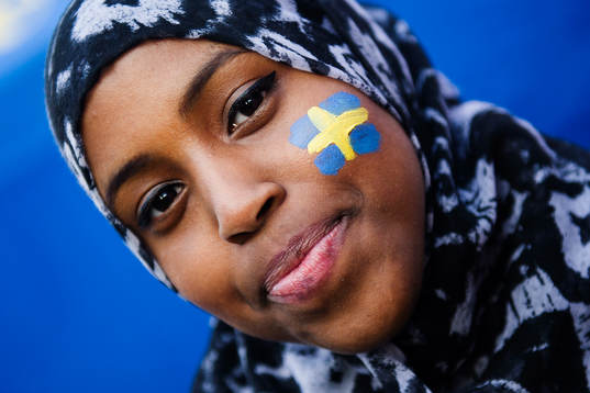 En tjej får en svensk flagga målad i ansiktet