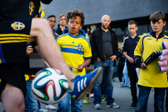 En ung kille är imponerad över en man som kickar med en