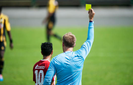 Varning, domaren visar gult kort, i matchen i division 3