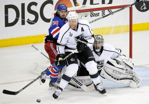 Los Angeles Kings defenseman Matt Greene (C) tries to clear