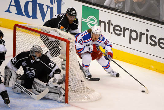 New York Rangers Carl Hagelin gets chased around the net by