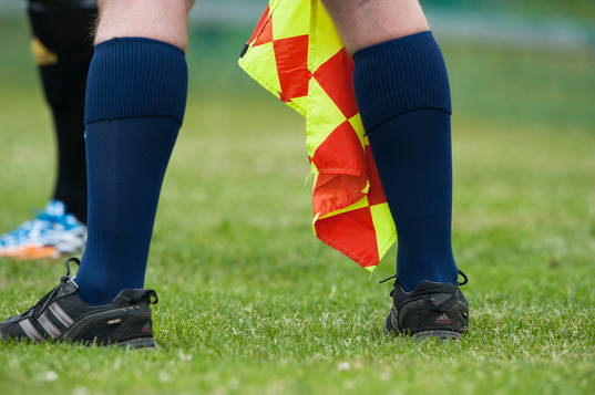 Assisterande domare med sin linjeflagga i matchen i