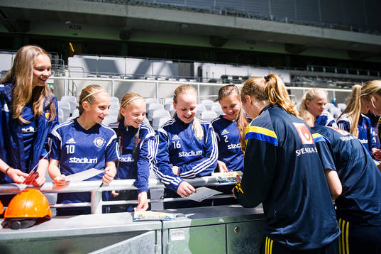 Sveriges spelare skriver autografer åt ett ungdomslag som