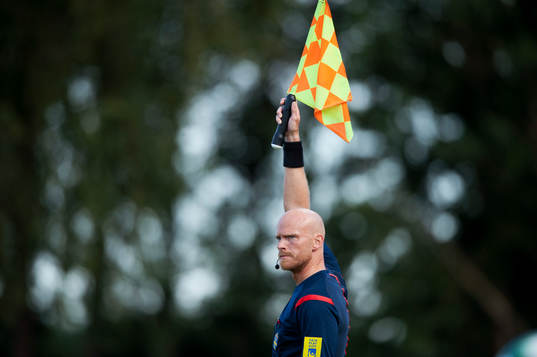 Assisterande domaren Per Uppsäll vinkar för offside i