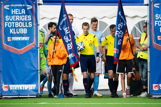 Spelare och domarteam går in på planen