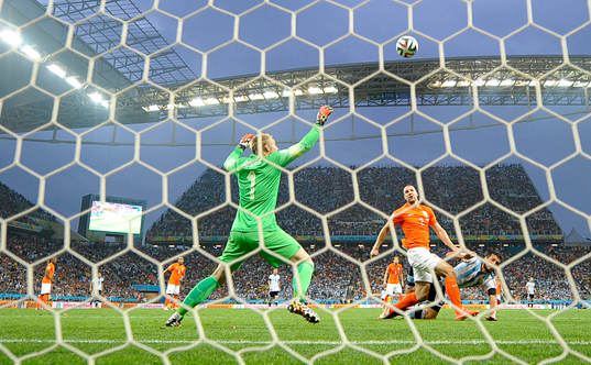 Hollands Ron Vlaar rensar undan framför Argentinas