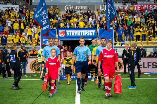 Spelarna går in på planen innan fotbollsmatchen i