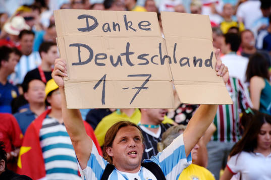 En Argentinsk supporter håller upp en skylt som tackar det