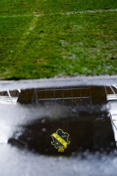 AIKs logga speglas i en vattenpöl när fotbollsmatchen i