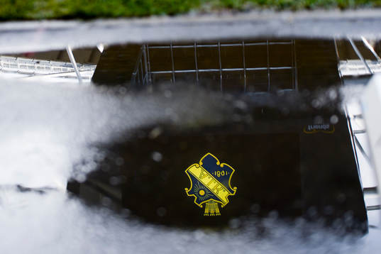 AIKs logga speglas i en vattenpöl när fotbollsmatchen i