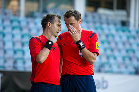 Domare Andreas Ekberg i samspråk med sin linjeman om