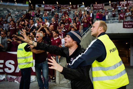 En supporter tar sig ner från läktaren men stoppas av