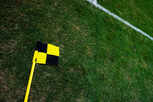 En hörnflagga ligger slängd på planen