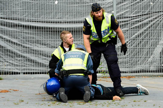 Polisen omhändertar en supporter som bråkade vid