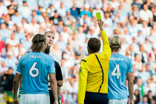 Malmö FFs målvakt Robin Olsen varnas av Domare Markus
