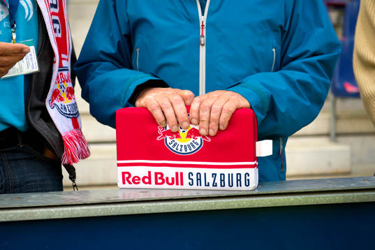 En Salzburg supporter håller en sittdyna med klubbens