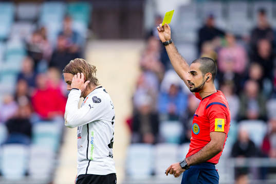 Mjällbys Danny Ervik får ett gult kort av domare Mohammed