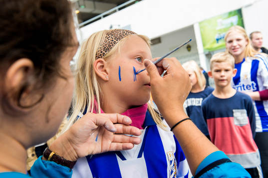 En ung IFK Göteborgssupporter blir målad innan