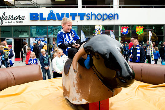 En ung supporter rider tjur innan fotbollsmatchen i