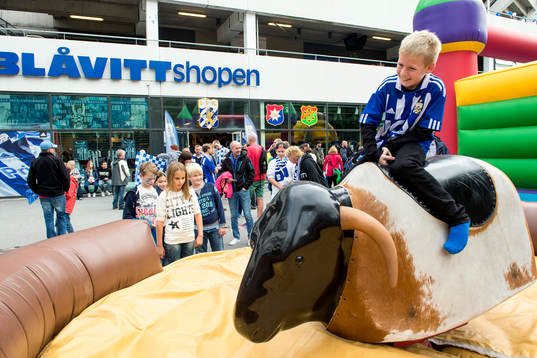 En ung supporter rider tjur innan fotbollsmatchen i