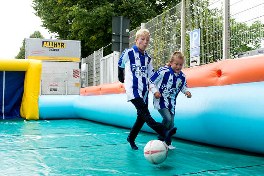 Unga supportrar spelar fotboll innan fotbollsmatchen i