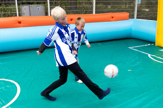 Unga supportrar spelar fotboll innan fotbollsmatchen i
