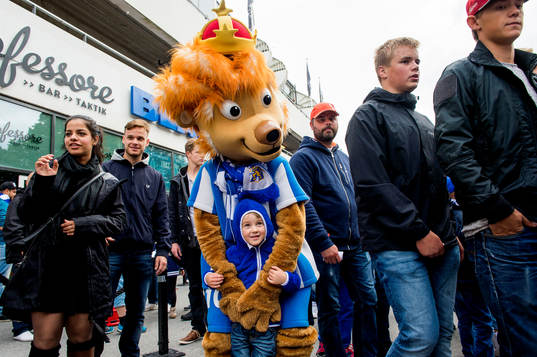 Maskoten Leo med unga supportrar innan fotbollsmatchen i