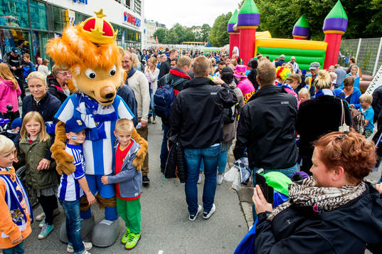 Maskoten Leo med unga supportrar innan fotbollsmatchen i