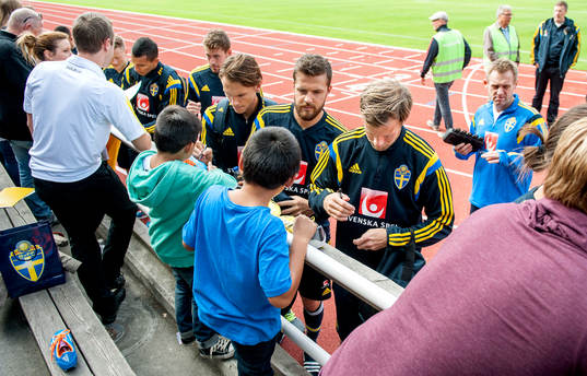 De svenska spelarna skriver autografer