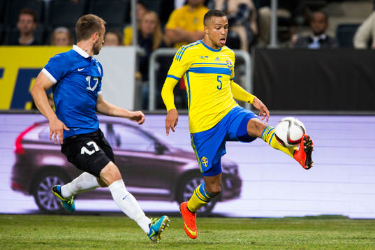 Sveriges Martin Olsson tar ner bollen framför Estlands