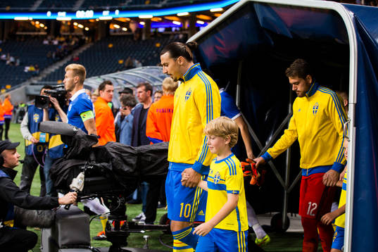 Sveriges Zlatan Ibrahimovic går ut på plan hand i hand
