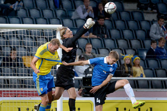 Sveriges Andreas Granqvist dras i tröjan av Estlands Igor