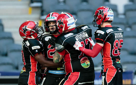 a vänster) gör en touchdown och firar med lagkamrater
