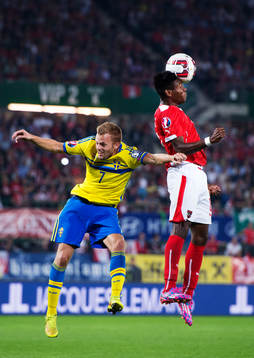 Sveriges Sebastian Larsson i en luftduell med Österrikes