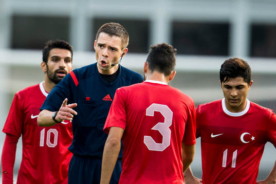 Domare Kevin John Clancy pratar med Turkiets Ugur Ciftci
