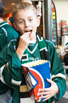 Ung supporter äter popcorn innan ishockeymatchen i SHL