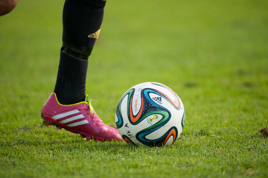Fotbollsskor Adidas och fotboll Adidas i matchen i