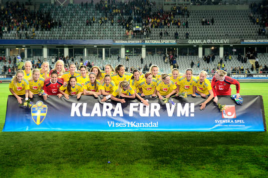 Sveriges spelare firar segern bakom en skylt "Klara för VM"
