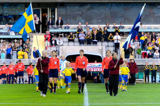 Lagen går in på arenan innan fotbollsmatchen i damernas