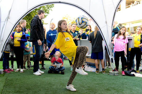 En tjej kickar boll i fan-zone
